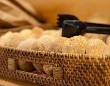 Beautifully golden fresh baked bread cooling on shelves at Serious Delights artisan scratch bakery.